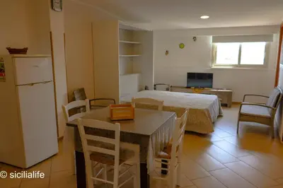 a bedroom with a bed with a blue and white quilt at Terrazza Solemar -four rooms in Castellammare del Golfo