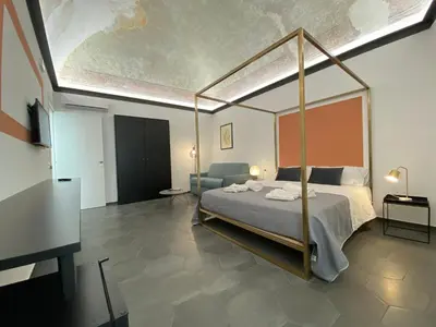 a bedroom with a canopy bed and a couch at B&B ALIVA in Alcamo