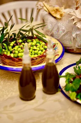 two bottles of honey on a table with a basket of fruit at Villa Dora con piscina in Trappeto
