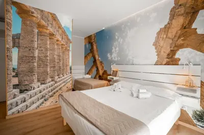 a bedroom with a white bed and a wall with ruins at Borghi di Belmonte in Palermo