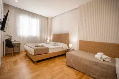 a hotel room with two beds and a desk at Borghi di Belmonte in Palermo