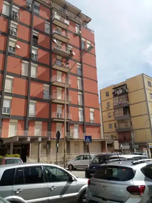 a parking lot with cars parked in front of a building at Desire'- Le Caprice in Palermo
