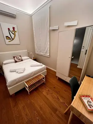 a bedroom with a bed with white sheets and a window at B&B TIVÌTTI in Palermo