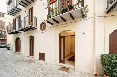 a white building with balconies on a street at Tarzanà 11 apartment - Cala di Palermo in Palermo