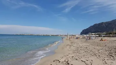 a group of people on a beach near the water at Airport Home TUREI & BRINGO Car Rental in Cinisi