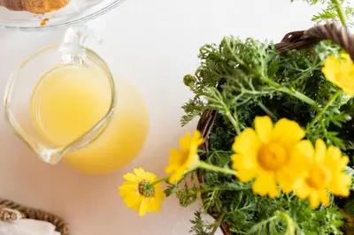 a glass of orange juice and flowers on a table at La Corte del Sole in Calatafimi
