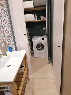 a bathroom with a sink and a washing machine at La casa nel Borgo in Scopello