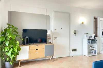 a living room with a television on a dresser at Il Mare in una Stanza by DomuSicily in Mondello