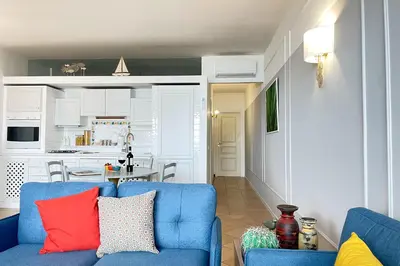 a living room with a blue couch and a kitchen at Il Mare in una Stanza by DomuSicily in Mondello