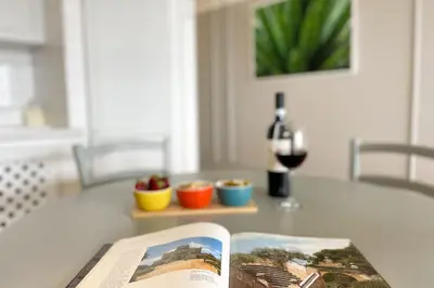 a book on a table with a glass of wine at Il Mare in una Stanza by DomuSicily in Mondello