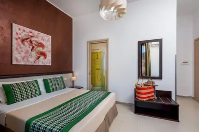 a bedroom with a large bed and a mirror at B&B A casa di Aurora rooms in San Vito lo Capo