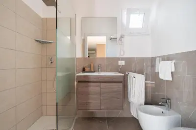 a bathroom with a sink and a toilet and a mirror at Attico 37 - Suite con terrazza privata e cucina in Palermo