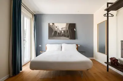 a large white bed in a room with a large window at Attico 37 - Comfort room con terrazza privata in Palermo