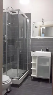 a bathroom with a shower and a toilet and a sink at Bed & Breakfast Amari 58 in Palermo