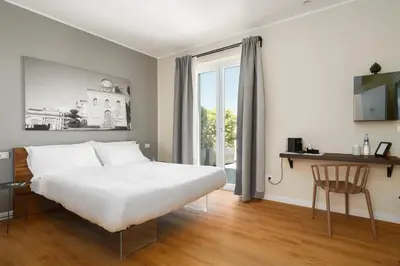 a bedroom with a large white bed and a window at Attico 37 - Comfort room con terrazza privata in Palermo