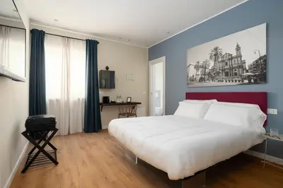 a bedroom with a large white bed and blue walls at Attico 37 - Comfort room con terrazza privata in Palermo