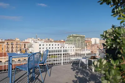 a blue table and chairs on a balcony with a city skyline at Attico 37 - Comfort room con terrazza privata in Palermo