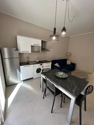 a kitchen and living room with a table and a refrigerator at Luce del golfo in Castellammare del Golfo