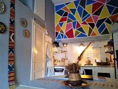 a kitchen with a table and a colorful tile wall at AlCasart in Alcamo