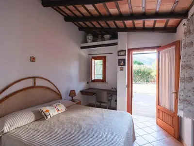 a bedroom with a bed and a desk and a door at Villa New Charme in Castellammare del Golfo