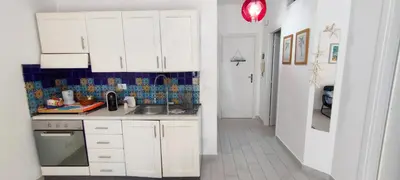 a kitchen with white cabinets and a sink at L'isola di Fimi in Isola delle Femmine