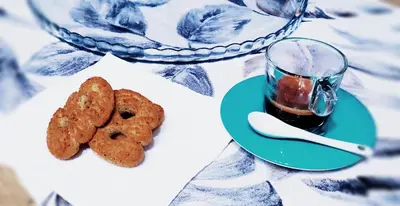 a table with a plate of cookies and a cup of tea at L'isola di Fimi in Isola delle Femmine