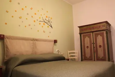 a bedroom with a bed and a wooden cabinet at La Casetta di Giò! in Castellammare del Golfo