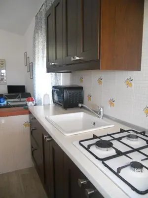 a kitchen with a sink and a stove top oven at CASE PUNTA MONACO by Trerose Properties con wi-fi e posto auto privato gratuito in San Vito lo Capo