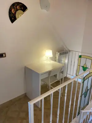 a room with a table and a lamp on a staircase at HELIOS House in Palermo