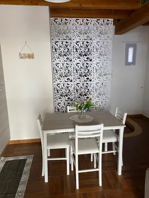 a table and chairs in a room with a wall at HELIOS House in Palermo