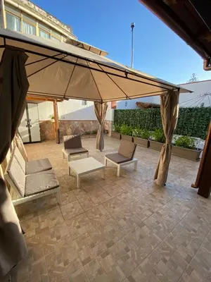 a patio with chairs and a large umbrella at HELIOS House in Palermo