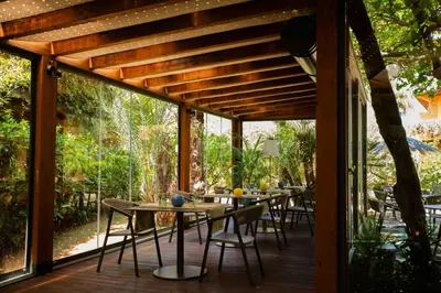 a patio with tables and chairs on a wooden deck at Magaggiari Hotel Resort in Cinisi