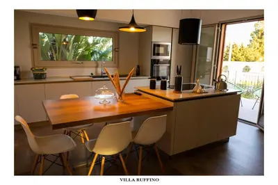 a kitchen with a wooden table and chairs at Appartamento in Villa con idromassaggio in Balestrate