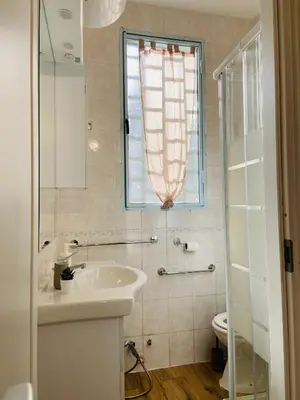 a bathroom with a sink and a window and a toilet at LA CASA DI TABBi in Palermo