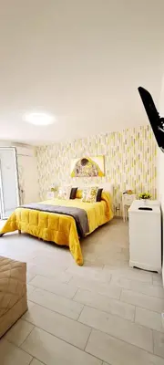 a bedroom with a large bed with a yellow blanket at Via Roma 35 Apartament in Monreale