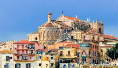 a group of buildings in front of a large building at Via Roma 35 Apartament in Monreale