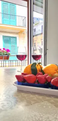 two glasses of wine next to a plate of fruit at Via Roma 35 Apartament in Monreale