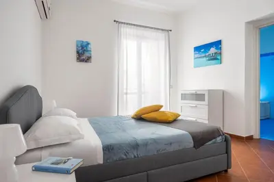 a white bedroom with a bed and a window at Sedie Volanti Apartment with Jacuzzi in Palermo
