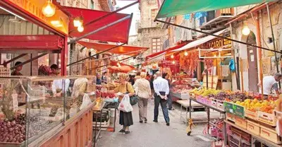 a group of people walking through an outdoor market at Casa dei Quattro Canti B&B in Palermo