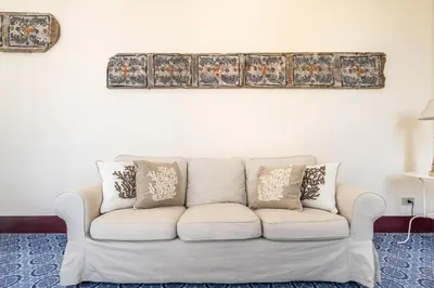 a white couch sitting in a living room with pillows at I Merli sull'acqua - Suite in Palermo