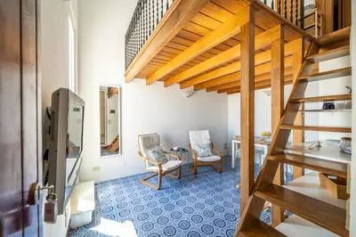 a room with a staircase and a table and chairs at I Merli sull'acqua - Suite in Palermo