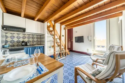 a kitchen and living room with a table and chairs at I Merli sull'acqua - Suite in Palermo