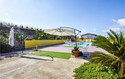 a patio with an umbrella and a swimming pool at Cozy Home In Caccamo With Kitchenette in Caccamo