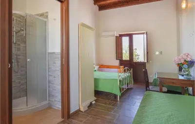 a bedroom with a bed and a glass shower at Cozy Home In Caccamo With Kitchenette in Caccamo