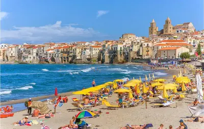 a group of people on a beach with yellow umbrellas at Cozy Home In Caccamo With Kitchenette in Caccamo