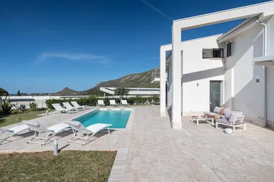 a villa with a pool and chairs and a house at Villa Costamante con piscina privata in Balata di Baida