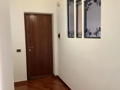 a hallway with a wooden door and pictures on the wall at Leo's Home in Palermo