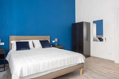 a blue bedroom with a bed and a blue wall at Le Cinque Stanze Palermo Room&Breakfast in Palermo