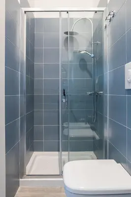 a bathroom with a glass shower with a toilet at Le Cinque Stanze Palermo Room&Breakfast in Palermo