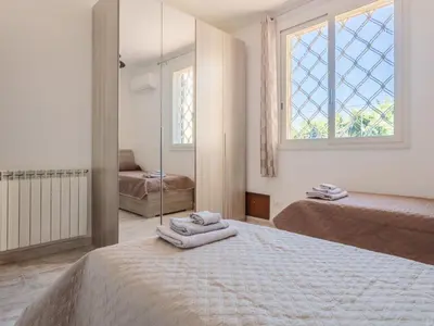 a white bedroom with two beds and a mirror at Holiday Home Alice by Interhome in Ficarazzi